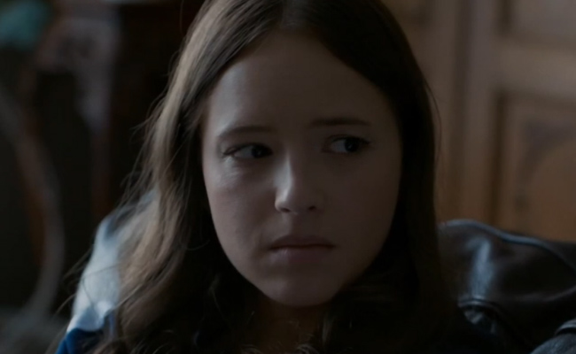 A close-up still of Magalie Langrais as Lizzy Marsh, a young woman with long brown hair, looking to the side with a concerned and pensive expression.