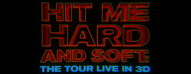 Title card for 2026 Billie Eilish concert film "Hit Me Hard and Soft: The Tour Live in 3D" with large, bold red and blue lettering and a glitch effect against a black background.