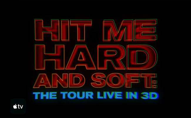 Title card for 2026 Billie Eilish concert film "Hit Me Hard and Soft: The Tour Live in 3D" with large, bold red and blue lettering and a glitch effect against a black background, with the Apple TV logo in the lower left corner.