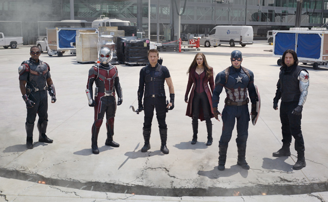 From "Captain America: Civil War", six superheroes stand in a line on an airport tarmac, facing the viewer. From left to right, they are in costumes resembling Falcon (Anthony Mackie), Ant-Man (Paul Rudd), Hawkeye (Jeremy Renner), Scarlet Witch (Elizabeth Olsen), Captain America (Chris Evans), and the Winter Soldier (Sebastian Stan). In the background, airport vehicles and buildings are visible.