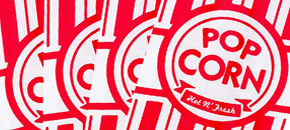 A close-up view of multiple overlapping red and white striped popcorn bags, each featuring a circular emblem with the text "POP CORN" above a banner that reads "Hot N' Fresh."