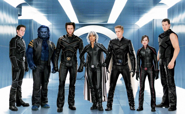 Still from "X-Men: The Last Stand". Seven characters in black leather X-Men uniforms stand in a sleek hallway with florescent overhead lighting. From left to right: Shawn Ashmore as Iceman, Kelsey Grammer as Beast, Hugh Jackman as Wolverine, Halle Berry as Storm, Ben Foster as Angel, Elliot Page as Kitty Pryde, Daniel Cudmore as Colossus.